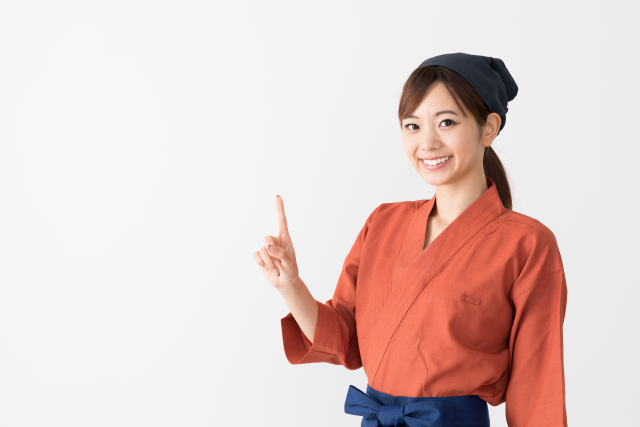 和風の制服を着てこちらに微笑む女性スタッフ
