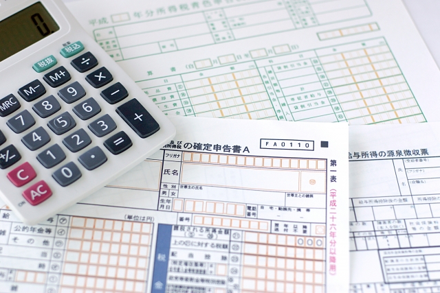 電卓と源泉徴収票と確定申告書のイメージ