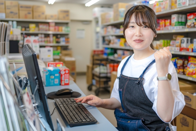 パソコンの前でガッツポーズをする女性スタッフ