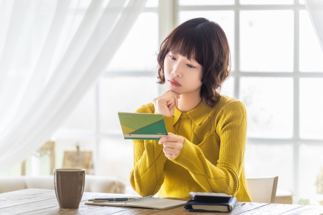 通帳を見て考える女性
