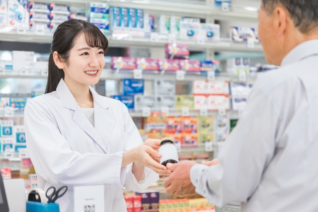 お客様に商品を渡すドラッグストアの女性スタッフ