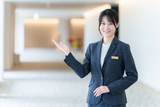 お客様をご案内するスーツ姿の女性スタッフ