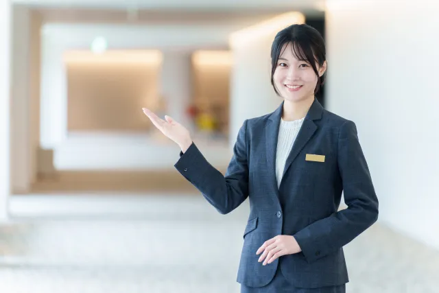 お客様をご案内するスーツ姿の女性スタッフ