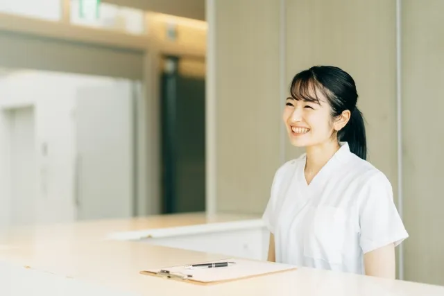 受付で笑顔で挨拶する女性
