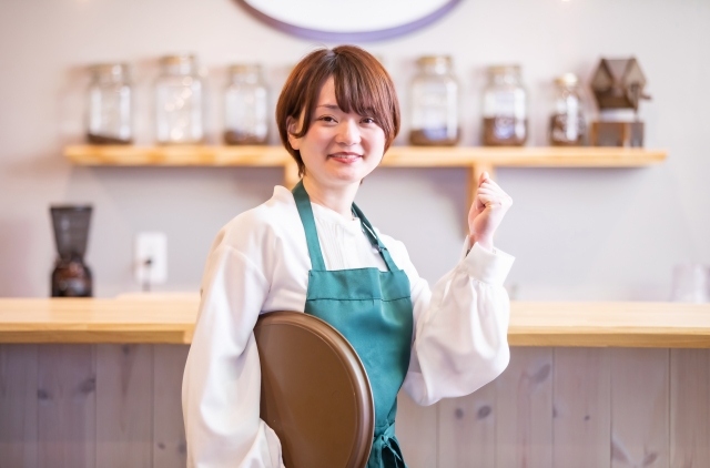 ガッツポーズをするカフェ店員の女性