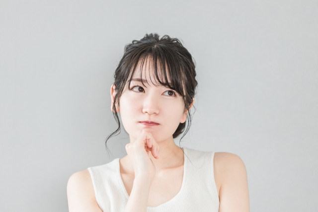 頬杖をついて考える・悩む女性
