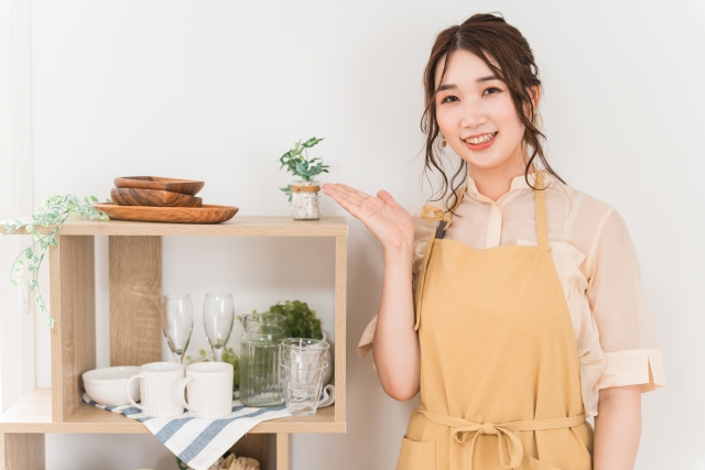 商品を笑顔で案内する女性スタッフ