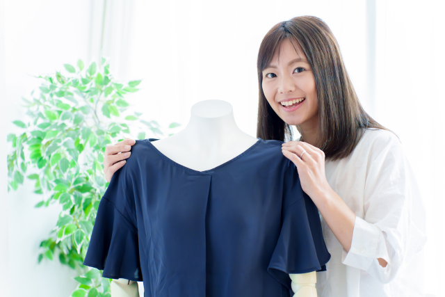 マネキンを使ってコーディネートを提案する女性スタッフ