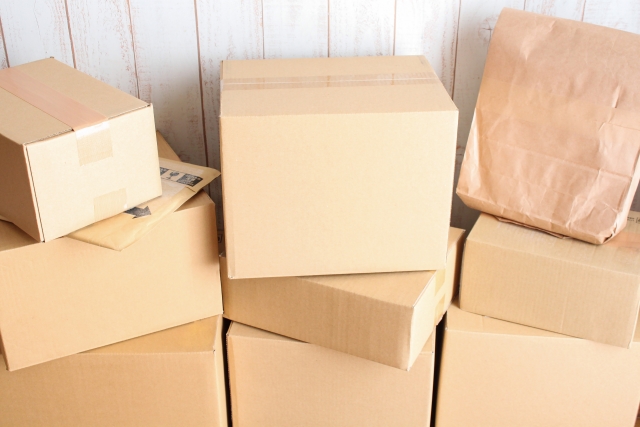 壁際に積まれた段ボールなどの荷物のイメージ