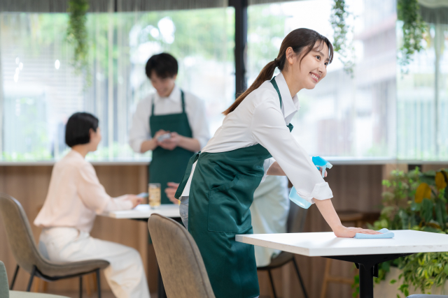 店内のテーブルを拭いている女性スタッフ