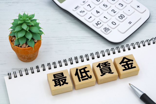 最低賃金のブロックが置かれた白いリングノート