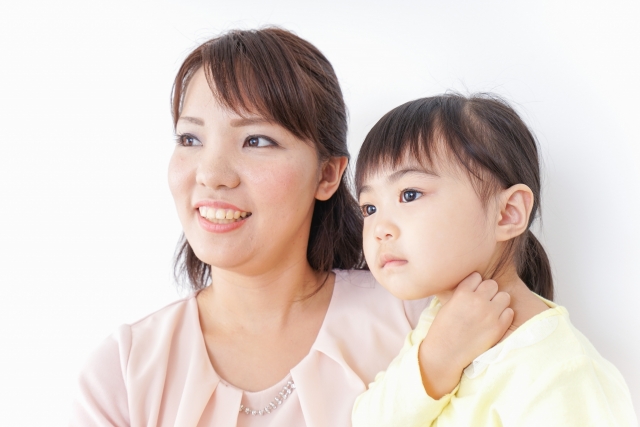 小さな女の子の隣で一緒に同じ方向を見つめる女性