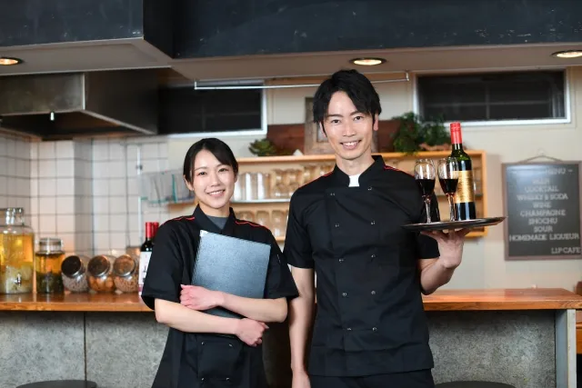 飲食店(レストラン)で働くカメラ目線の男女