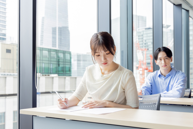 試験会場で試験を受ける受験者