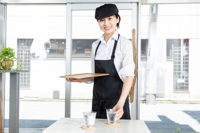 お客様の席に水を2つ届ける女性店員