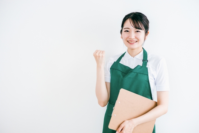 バインダーを片手にガッツポーズする女性店員