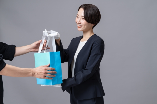 お客様に商品を手渡すショートカットの女性店員