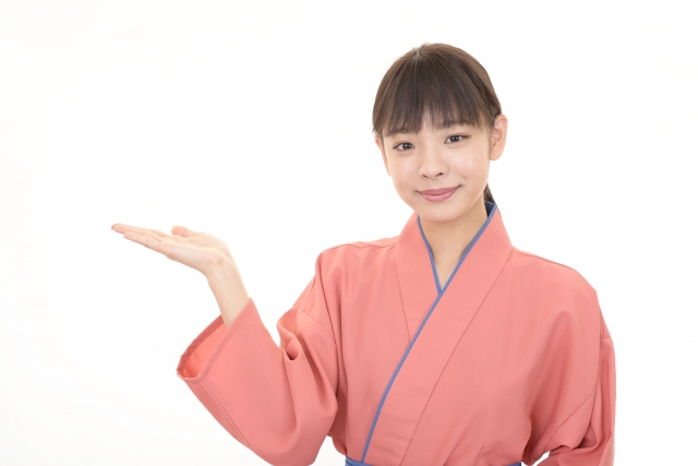割烹着姿でお客様にご案内する女性スタッフ
