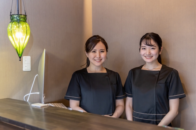 サロンの受付カウンターに立つ2人の女性スタッフ