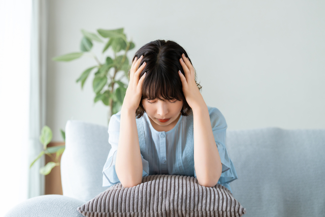 頭を抱えて座り込む女性