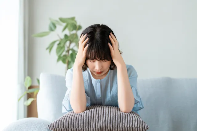 頭を抱えて座り込む女性