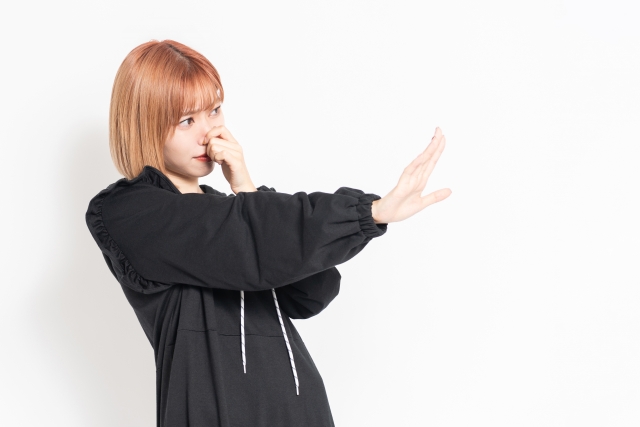 鼻をつまむ女性