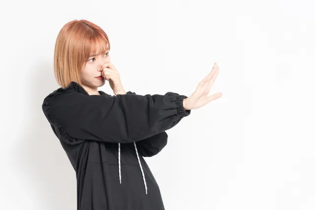 鼻をつまむ女性