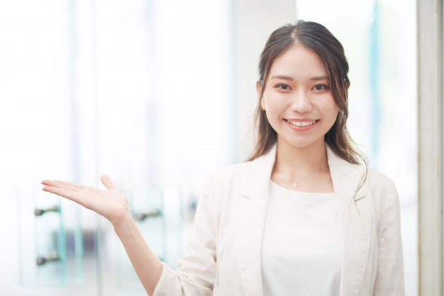 微笑みながらお客様をご案内するハーフアップ姿の女性