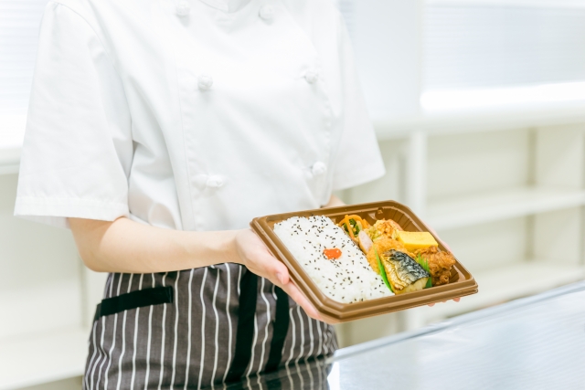 お弁当を持つ店員の手元