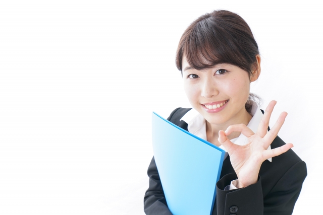 片手でOKマークを作るスーツの女性
