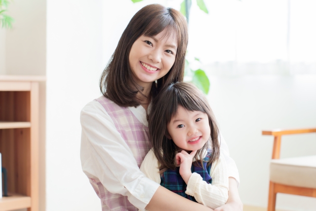 エプロン姿で笑顔を浮かべる女性と子ども