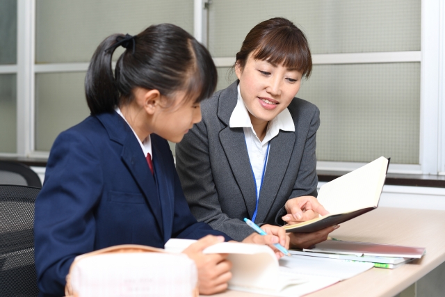 1対1で指導を行う女性講師とその生徒である女子学生