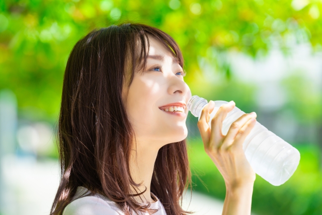 ペットボトルの水を飲む女性