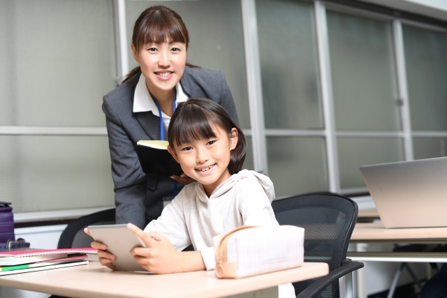 勉強中の女子生徒と指導にあたる女性講師