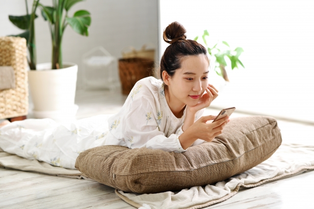 スマホで調べ物をする若い女性