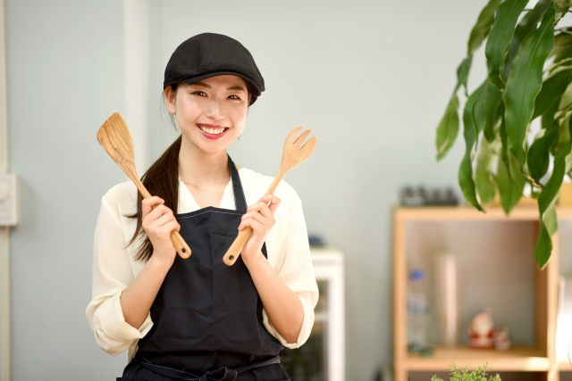 調理器具を手に持ちこちらに微笑む女性店員