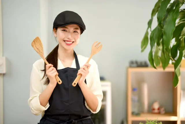 調理器具を手に持ちこちらに微笑む女性店員