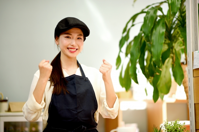 ガッツポーズをしながらこちらに微笑む女性店員