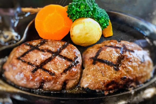 網目の付いた出来立てのハンバーグが2つ並ぶイメージ
