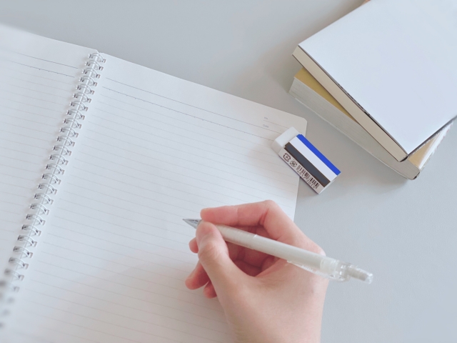 勉強に取り組む人の手とノートとペン