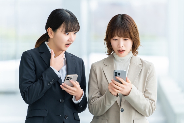 スマホを見て驚く女性