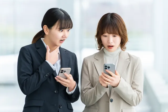 スマホを見て驚く女性