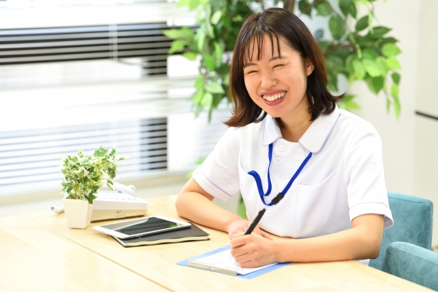 笑顔でメモを取る白衣の女性