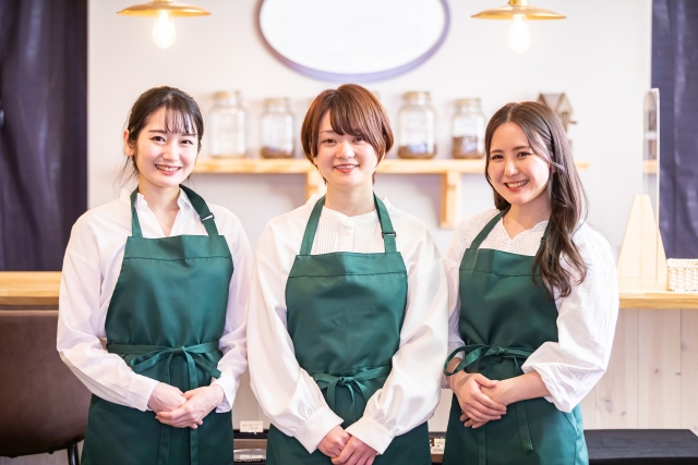 お店のカウンター前に横並びに立つ3人の女性スタッフ