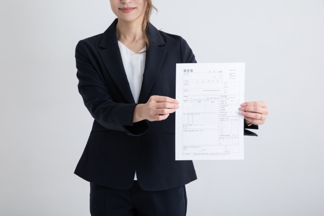 履歴書を持ったスーツの女性