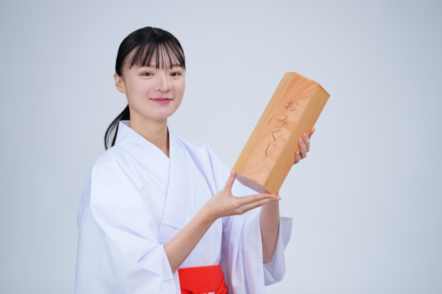 おみくじの箱を持った巫女装束の女性