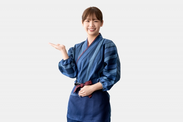 こちらに微笑みながら案内する女性スタッフ