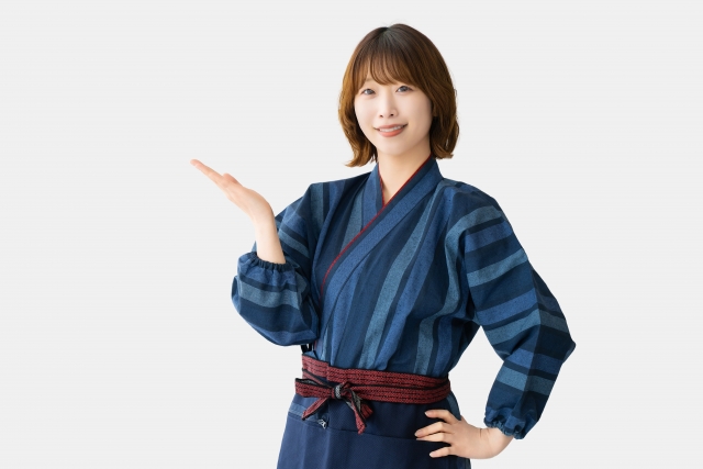 商品やおすすめ情報を紹介するように手を差し出している女性スタッフ