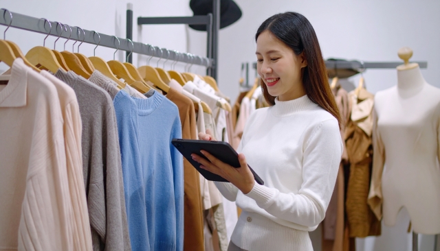 タブレットで商品の在庫を確認するアパレル店の女性スタッフ