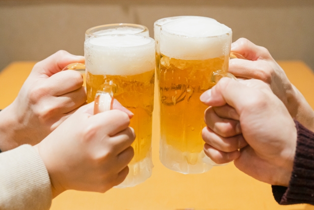 ビールを片手に乾杯する４人の男女の手元のアップ